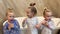 Little sisters triplets twins brushing their teeth in the bathroom in front of the mirror