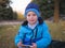 Little Slavic boy child portrait in spring or autumn on the lawn in a city park