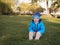 Little Slavic boy child portrait in spring or autumn on the lawn in a city park