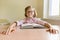 Little smart girl with glasses reading large book