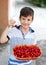 Little smiley caucasian boy holding cherry