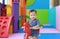 Little smiling baby boy playing horse on playground, wooden rocking