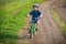 Little smiling boy ride on bike on rural landscape