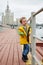 Little smiling boy in yellow jacket stands on