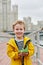 Little smiling boy in yellow jacket stands on