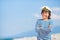 Little smiling captain boy looks into the distance on a blue sky background with place for text