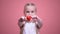 Little smiling girl with braids showing toy heart at camera closeup, charity