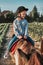 Little smiling girl learning horseback riding