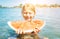 Little smiling girl portrait eating a red watermelon while she enjoying a splashing in river waves on the beach