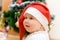 Little smiling girl in red Santa hat