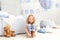 Little smiling girl in a white T-shirt and jeans sits on the background of a decorative balloon. The child plays in the children`s