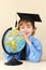 Little smiling professor in academic hat with globe