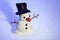 Little snowman made of plasticine standing on real snow