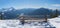 Little snowman sitting at a wooden bench in the bavarian alps. view to zugspitze and garmisch