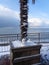 Little snowman under palm tree on snowy seaside promenade