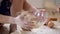 The little son helps mother to involve ingredients on dough in a transparent bowl in kitchen