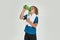 Little sportive boy child in sportswear drinking water from the bottle while standing with towel around his neck