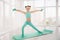 Little sporty girl gymnast in sportswear doing exercises on a mat indoor