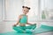 Little sporty girl gymnast in sportswear doing exercises on a mat indoor