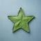 Little Star: A Quirky Green Cloth Star On A Blue Surface
