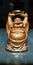 A little statue of Laughing Buddha in golden colour.