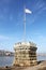 Little stone tower with flag marking the Lipotvaros harbor. The Danube river and a part of the right bank of Budapest