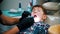 A little stressful boy with damaged baby teeth having a treatment in modern dentistry - examination of the oral cavity