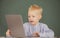 Little student boy using laptop computer in school class. Little funny programmer.