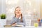 Little student girl sitting at the table and reading a book. The child shows a sign shh. The concept of education and school.