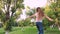 Little sweet girl with long hair dancing in the park