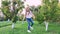 Little sweet girl with long hair dancing in the park garden.