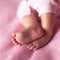 Little sweet legs of baby girl on pink background. Concept: kids, parenthood, family, baby shower. Square format for social media