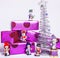 Little sweet stylish snowmen toys with purple gifts and silver tree, on white close up, sants claus red hat