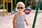 Little tanned girl in sunglasses on the playground. Portrait