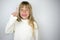 Little tanned girl in white badlon on a gray background.