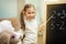 Little teacher. Beautiful young girl is teaching toys at home on blackboard.