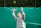 Little tennis player on a blurred green background