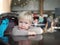 Little thoughtful boy sits at a table resting his chin on his fo