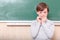 Little thrilled pupil standing at blackboard