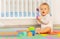 Little toddler baby boy play toys in nursery room