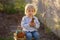 Little toddler boy, eating chocolate bunny in garden on sunset, easter eggs