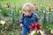 Little toddler boy on lily field in summer