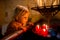 Little toddler boy, praying in chapel with candles in front