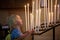 Little toddler boy, praying in chapel with candles in front