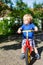 Little toddler boy riding on his bycicle in summer