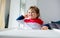 Little toddler boy sitting in a chair for feeding in a room in breakfast time