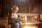 Little toddler boy, sitting on old vintage bench, holding books in attic