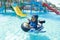 Little toddler boy swimming in inflatable ring in pool