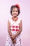 Little toddler girl child in white and red patch gown wearing colorful necklace