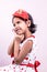 Little toddler girl child in white and red patch gown wearing colorful necklace holding hands on cheek